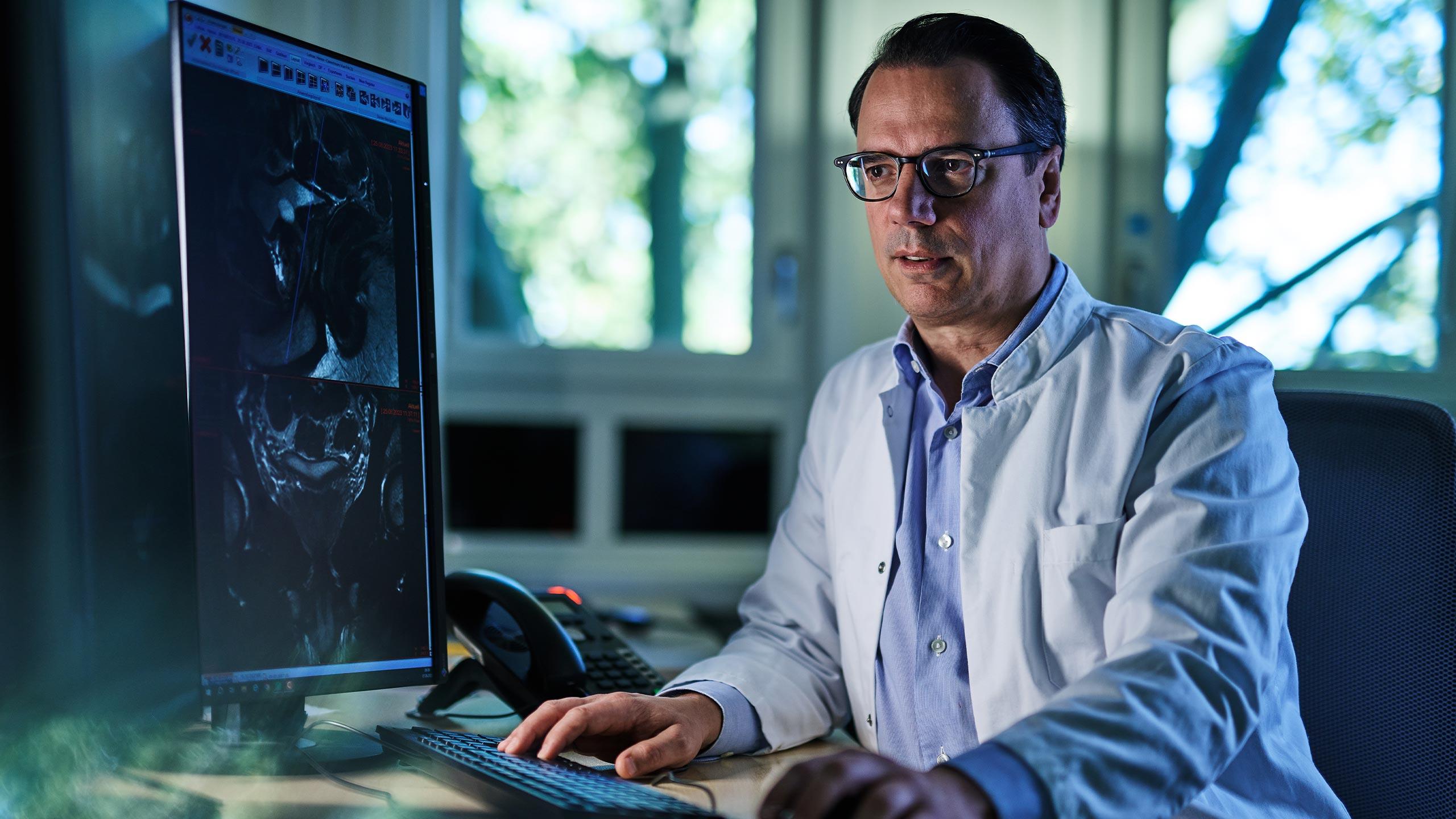 Dr. med. Matthias Röthke betrachtet Befund am Computer